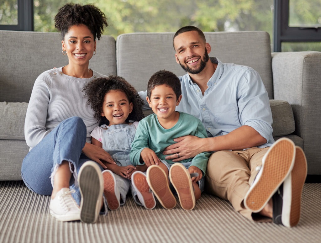 Cuide da sua saúde com inteligência e economia 2 happy family portrait bonding living room floor smile relax their home together love children content parents loving enjoying day indoors with excited smiling kids